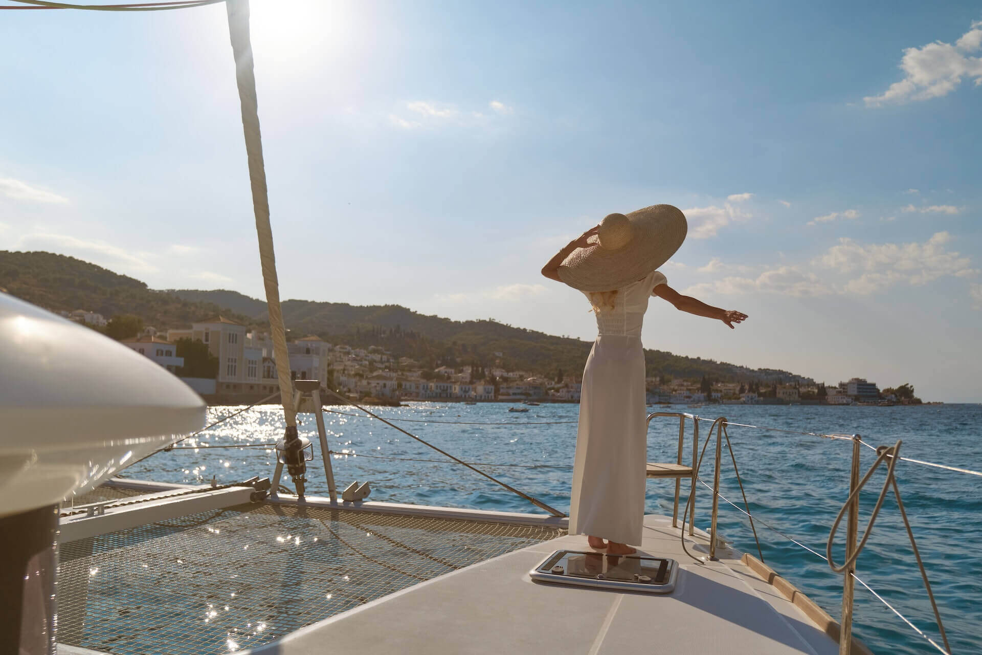 beautiful-woman-wearing-straw-hat-white-dress-yacht-enjoys-journey-spetses-greece-europe