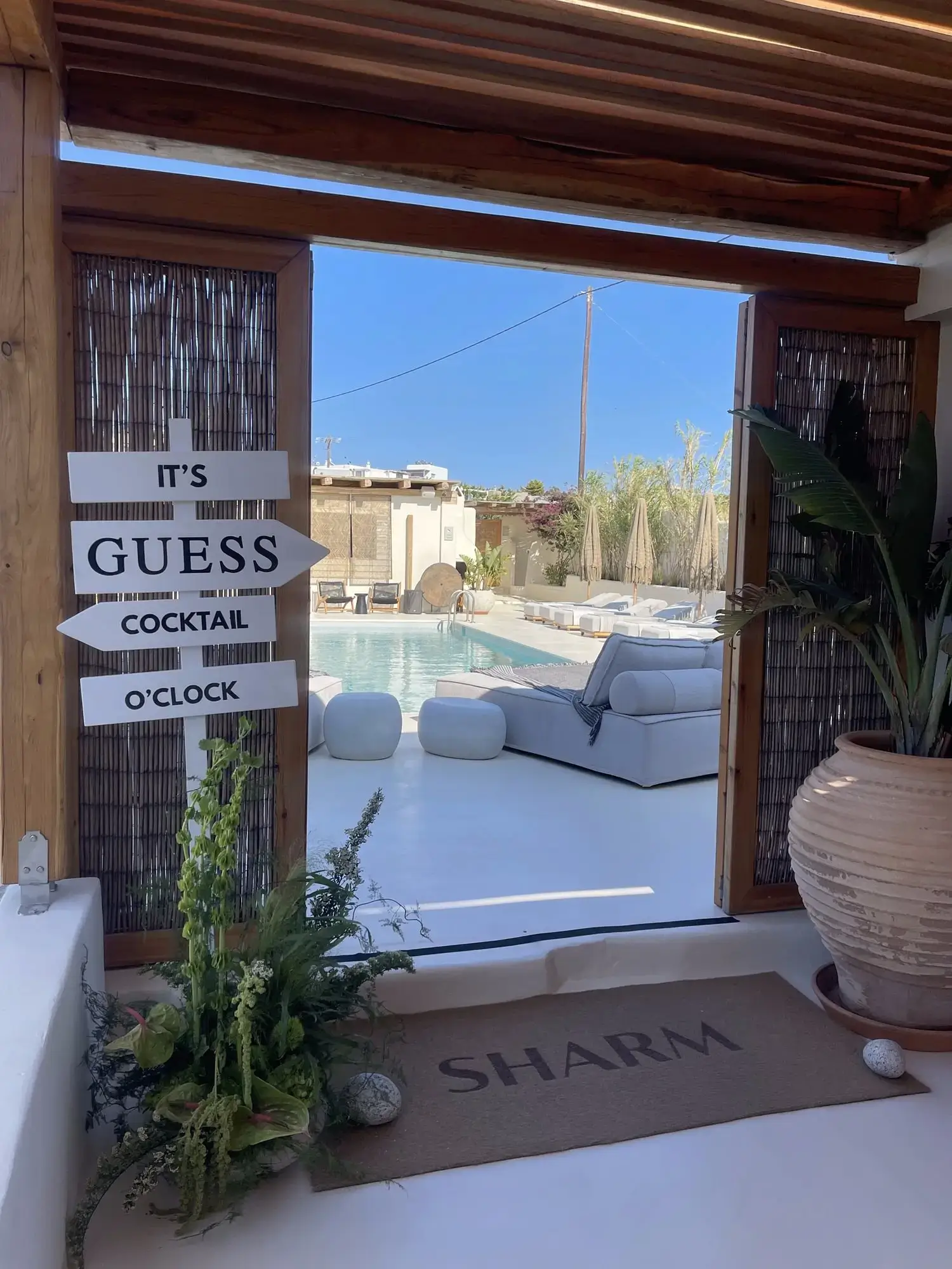 GUESS cocktail welcome event setup at the hotel with branded signage and pool views