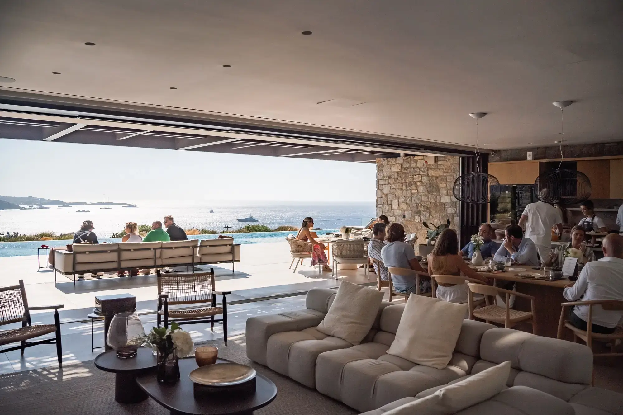 Guests gather for an intimate dining experience with panoramic views of the Aegean