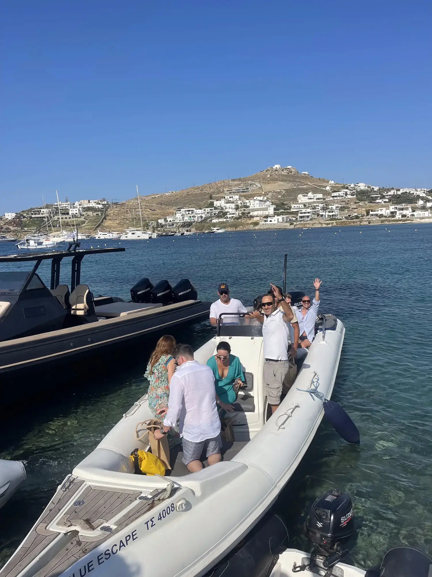 Private speedboat transfer between venues with the Mykonos coastline behind